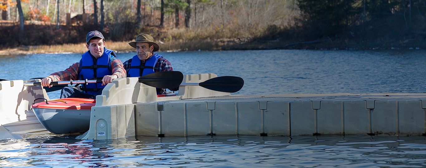 Father and son sitting in kayak on launch
