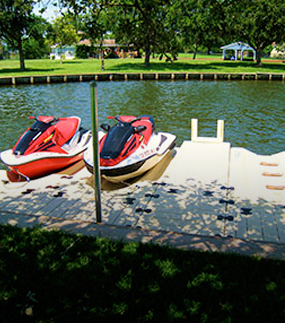 Two red jet skis are parked in their ports