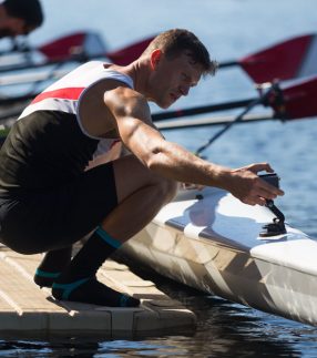 Man fixing his boat on a low profile dock