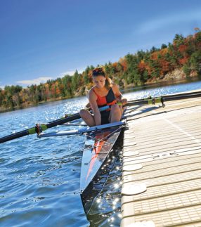 Girl rowing a boat near a low profile dock