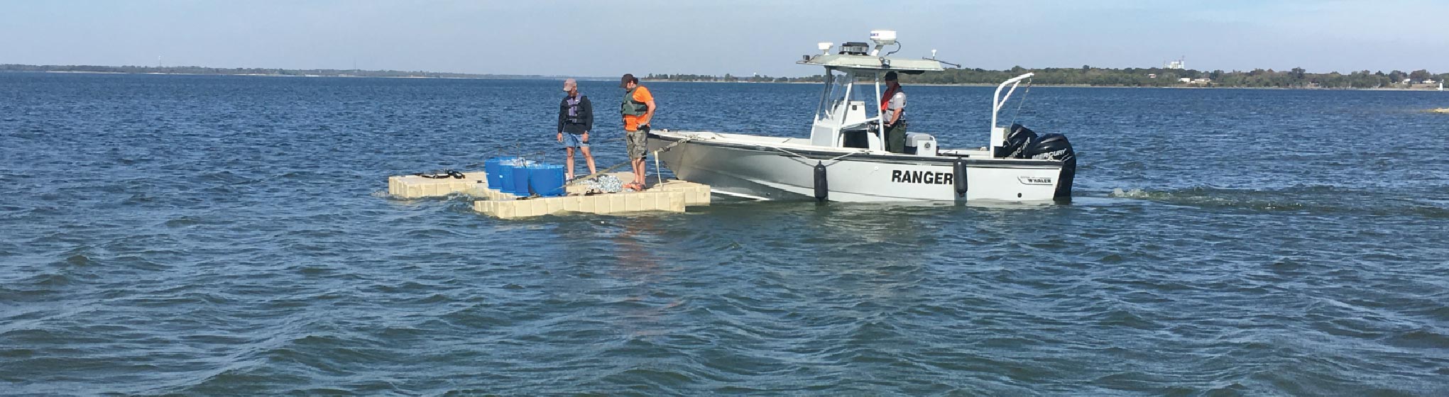 Ranger on boat with people inspecting floating dock