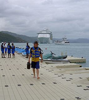 A man in a life vest walks along a dock