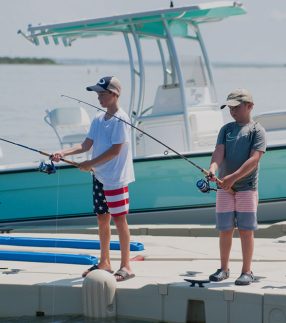 Boys fishing off of boat dock