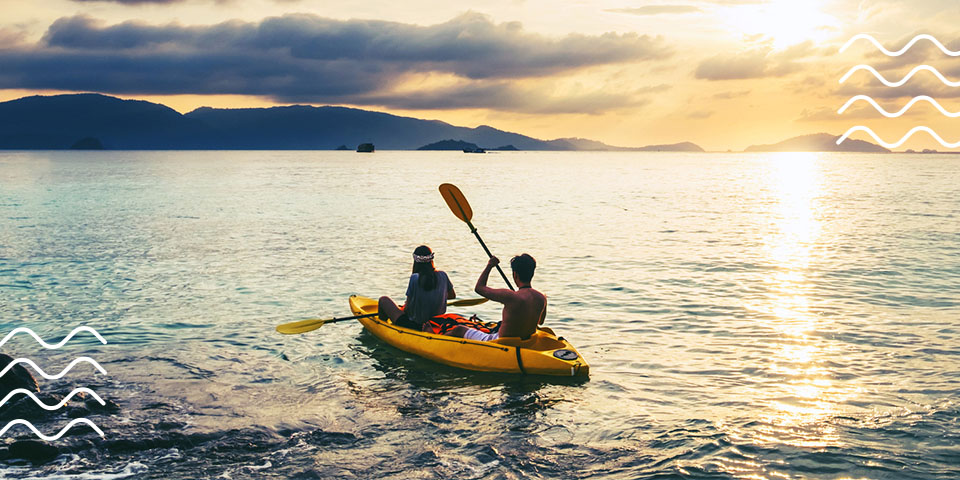 Two people kayaking out into the water.