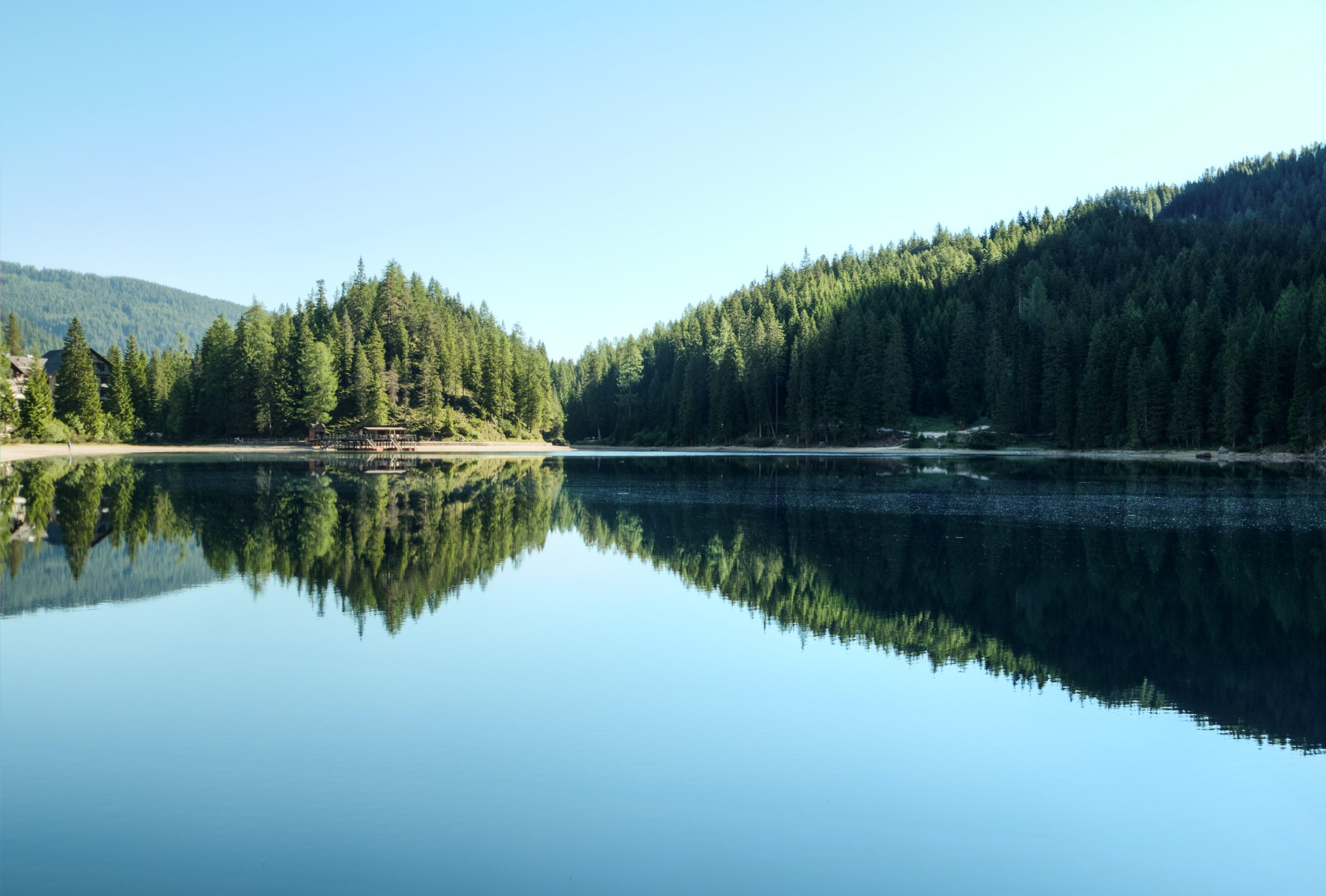 Scenic view of lake with house behind the trees