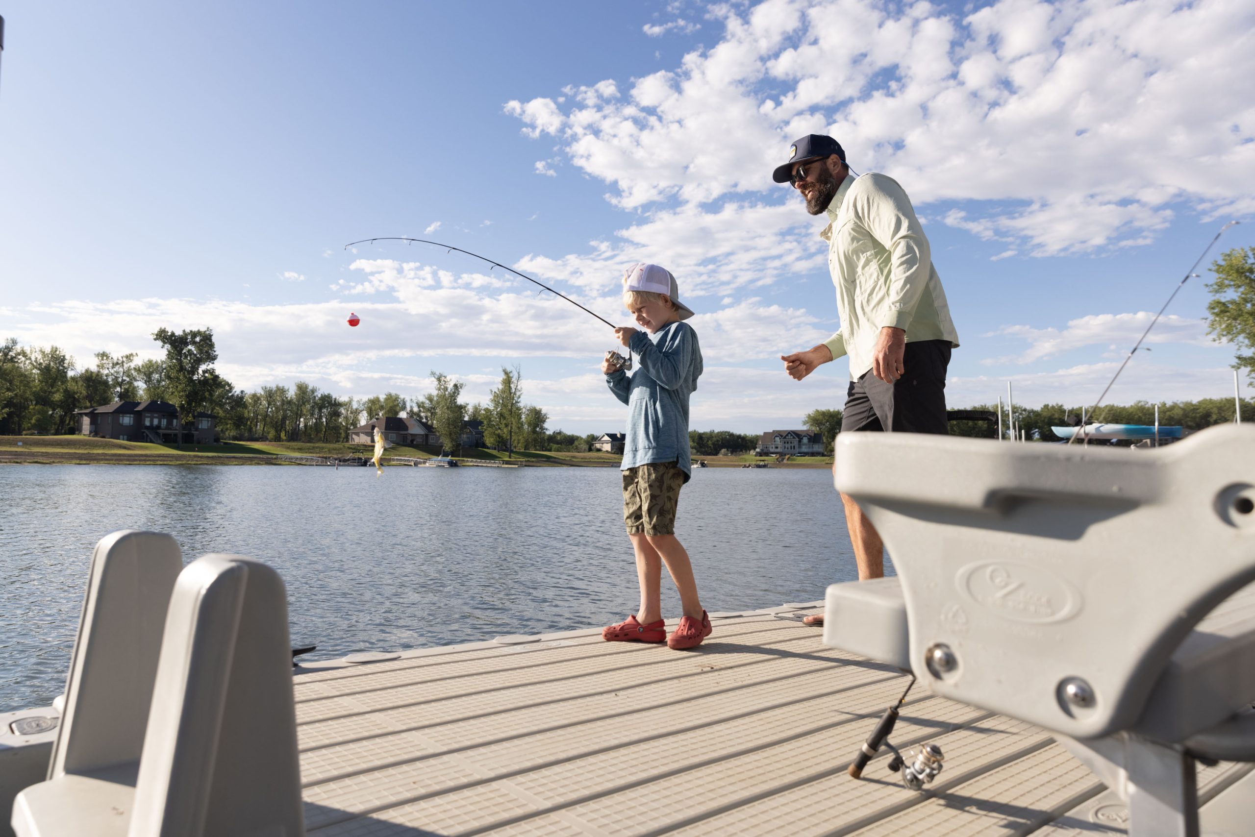 Man teaching little boy to fish